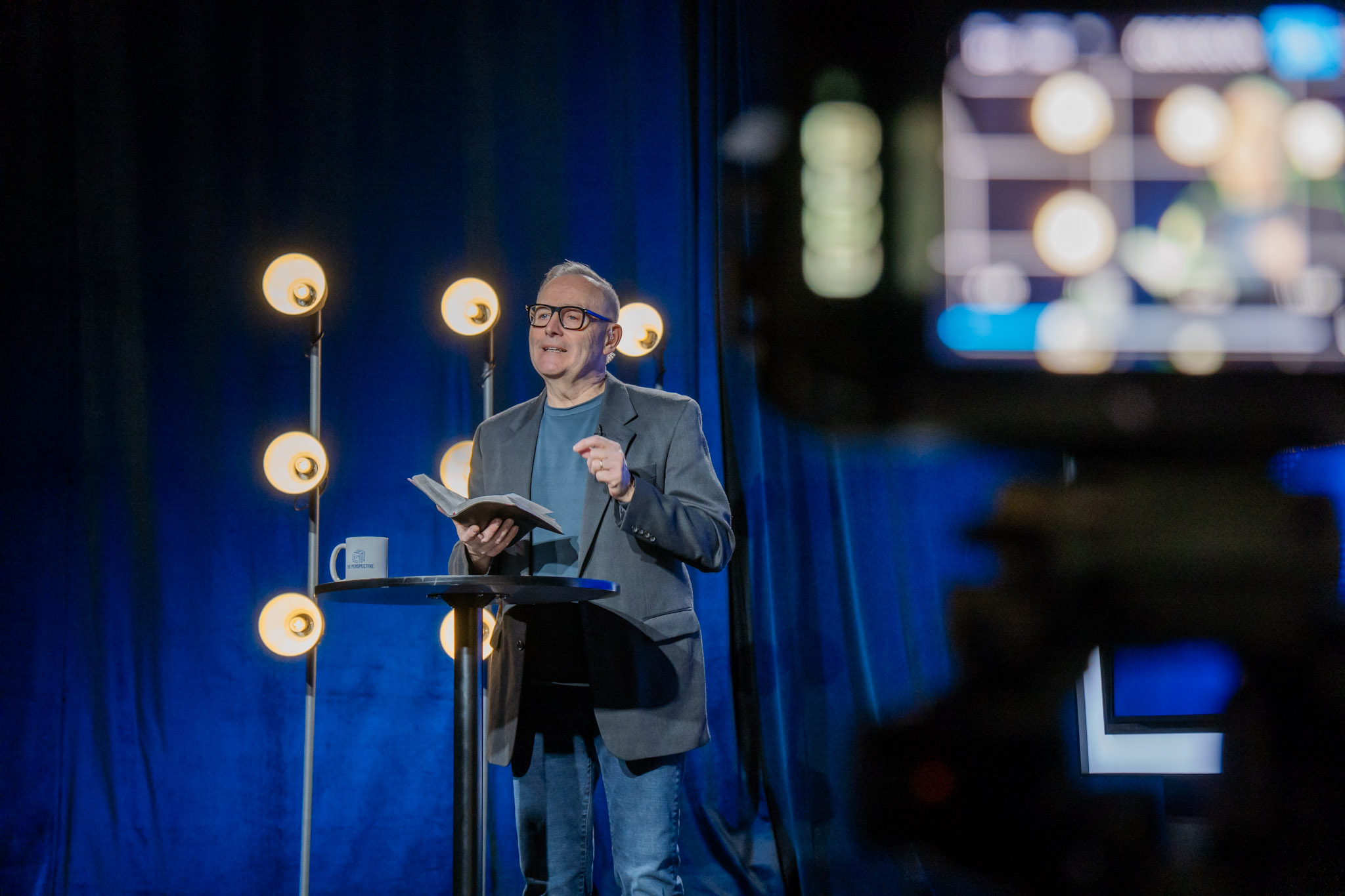 Speaker presenting under warm stage lights