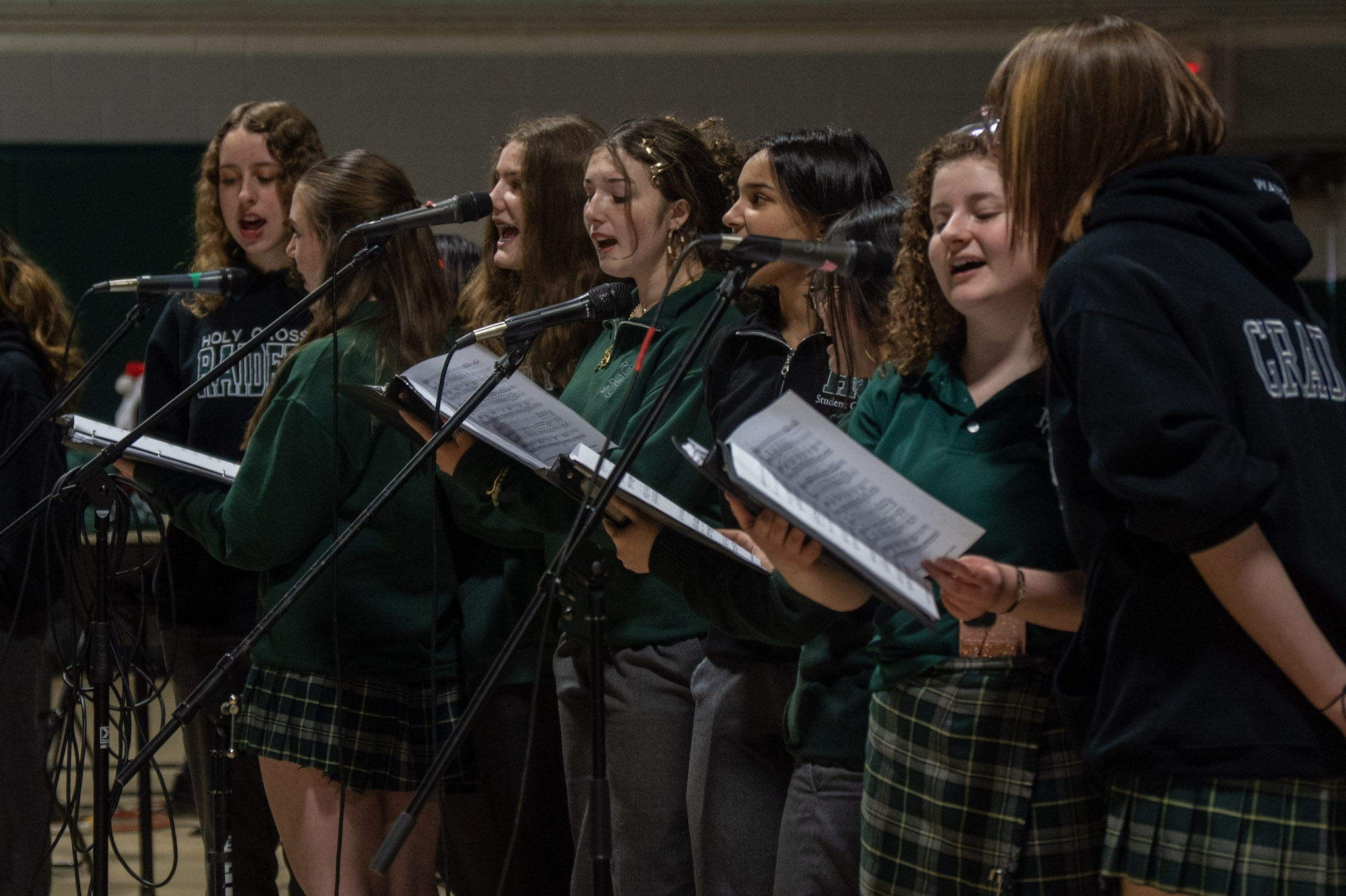 Student choir singing into microphones
